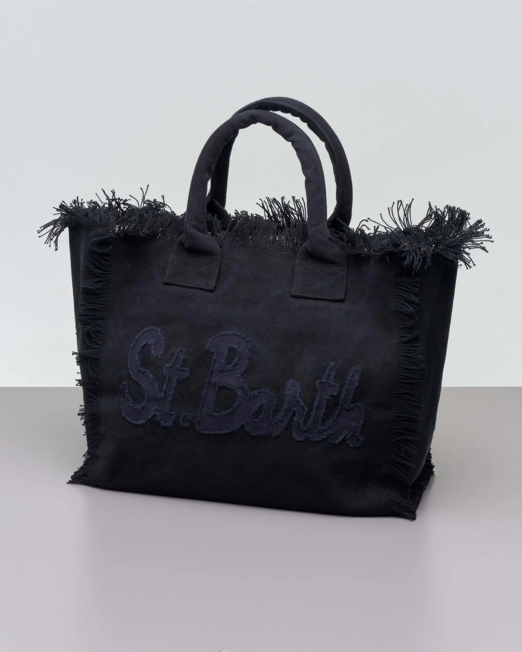 Borsa in canvas di cotone nera con scritta logo cucita in tono e frange ai lati