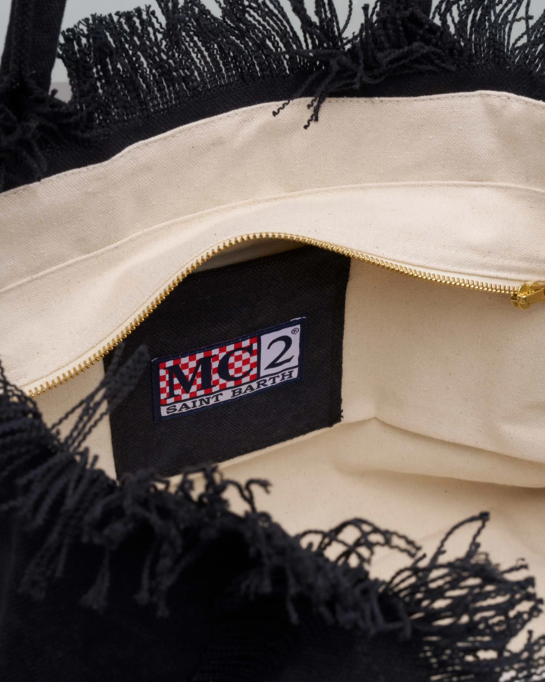 Borsa in canvas di cotone nera con scritta logo cucita in tono e frange ai lati